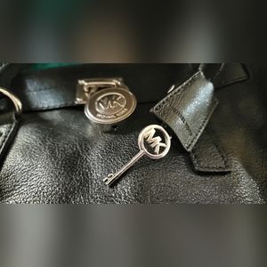 Black Michael Kors purse with lock and key